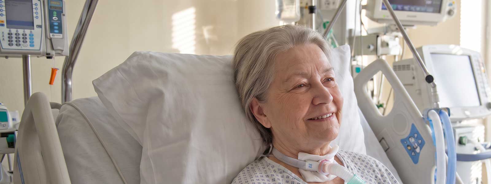 Eine Frau in einem Krankenbett mit einem Tracheostoma